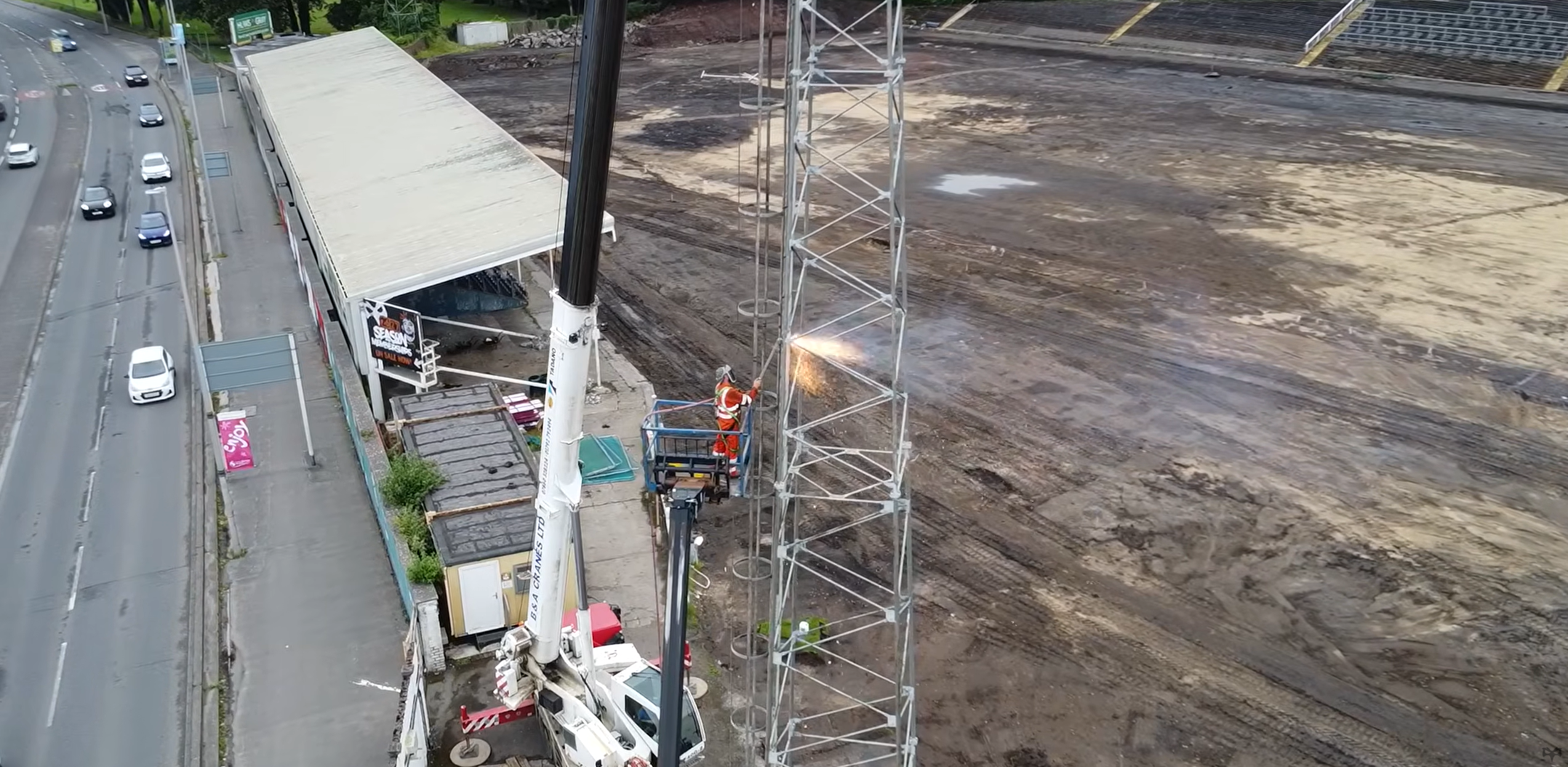 A man halfway of the flodlights cuts the metal as St helen's iconic flodlights are taken down during Ospreys' historic redevelopment of the ground  