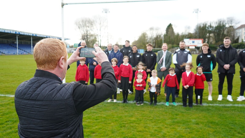 Community members photographed under the posts at St Helen's